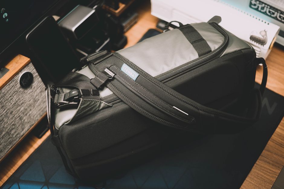A modern black and gray backpack placed on a wooden desk, ideal for travel or daily use.
